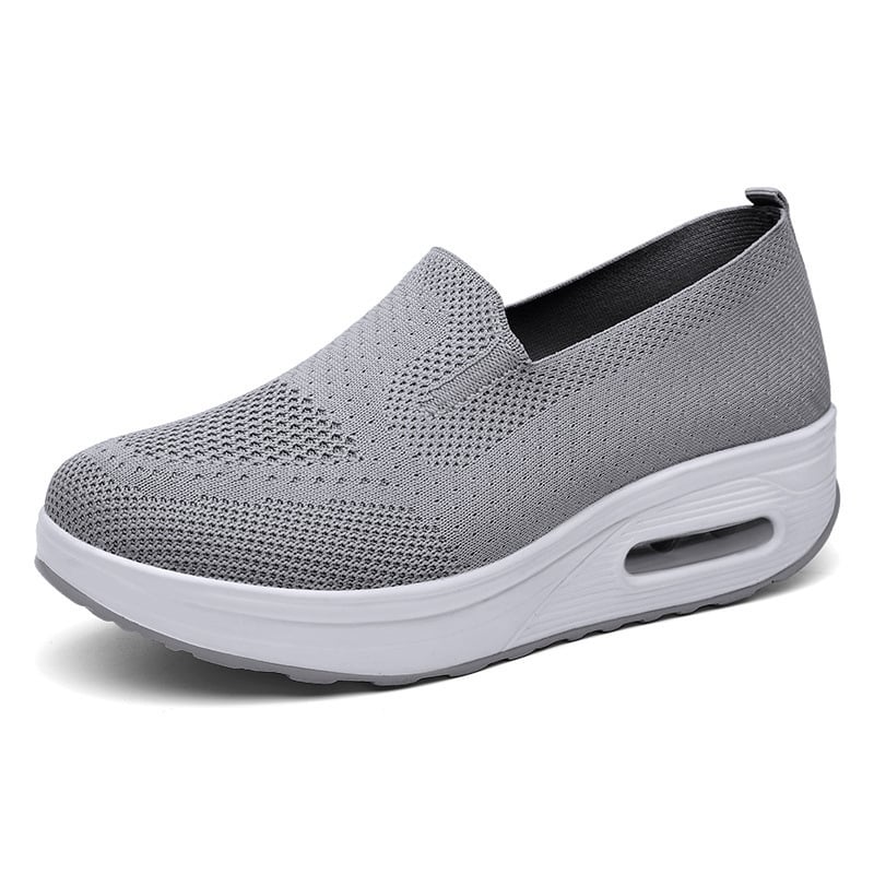 Grauer Damen-Sneaker mit Keilabsatz, atmungsaktivem Strick-Obermaterial und weißer Sohle. Bequem, modisch, ideal für Freizeit und Alltag.