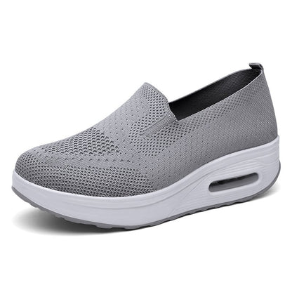 Grauer Damen-Sneaker mit Keilabsatz, atmungsaktivem Strick-Obermaterial und weißer Sohle. Bequem, modisch, ideal für Freizeit und Alltag.