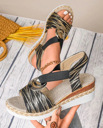 Damen-Sandalen mit Keilabsatz, schwarz-goldenes Muster, elastische Riemen, bequeme Sohle, modisches Design, ideal für Sommermode.