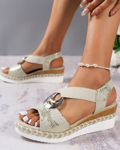 Damen Sandalen mit Keilabsatz, Schlangenleder-Optik, cremefarben, mit Schmuckdetail, ideal für Sommermode und elegante Freizeitoutfits.