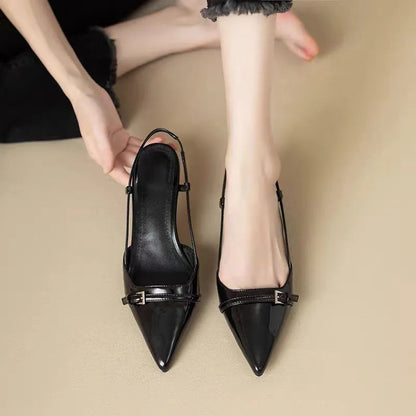 Schwarze spitze Slingback-Ballerinas mit Schnalle, getragen von einer Person auf beigem Hintergrund. Elegante Damen-Sommerschuhe, modisch und stilvoll.
