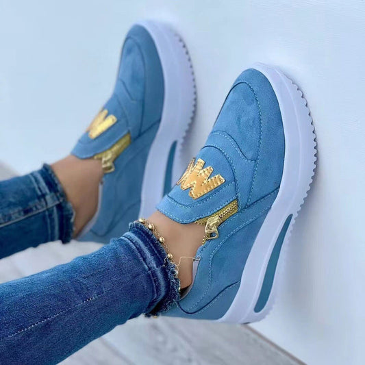 Blaue Damen-Sneaker mit goldenen Details, seitlichem Reißverschluss und weißer Sohle. Modische Freizeitschuhe, ideal für trendige Outfits.