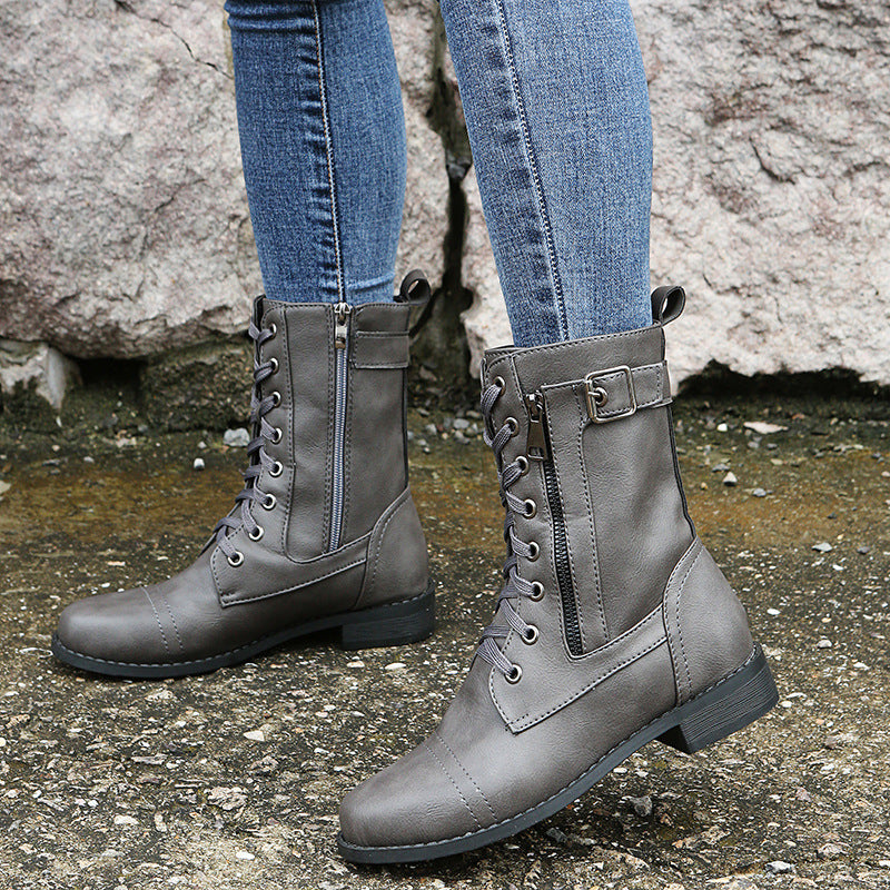 Graue Damenstiefel aus Leder mit Schnürung und Reißverschluss, getragen zu blauen Jeans. Modische Herbst- und Winterstiefel für Damen.