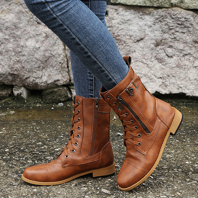 Braune Lederstiefel mit Schnürung und Reißverschluss, getragen mit blauen Jeans. Modische Damenstiefel für Herbst und Winter.