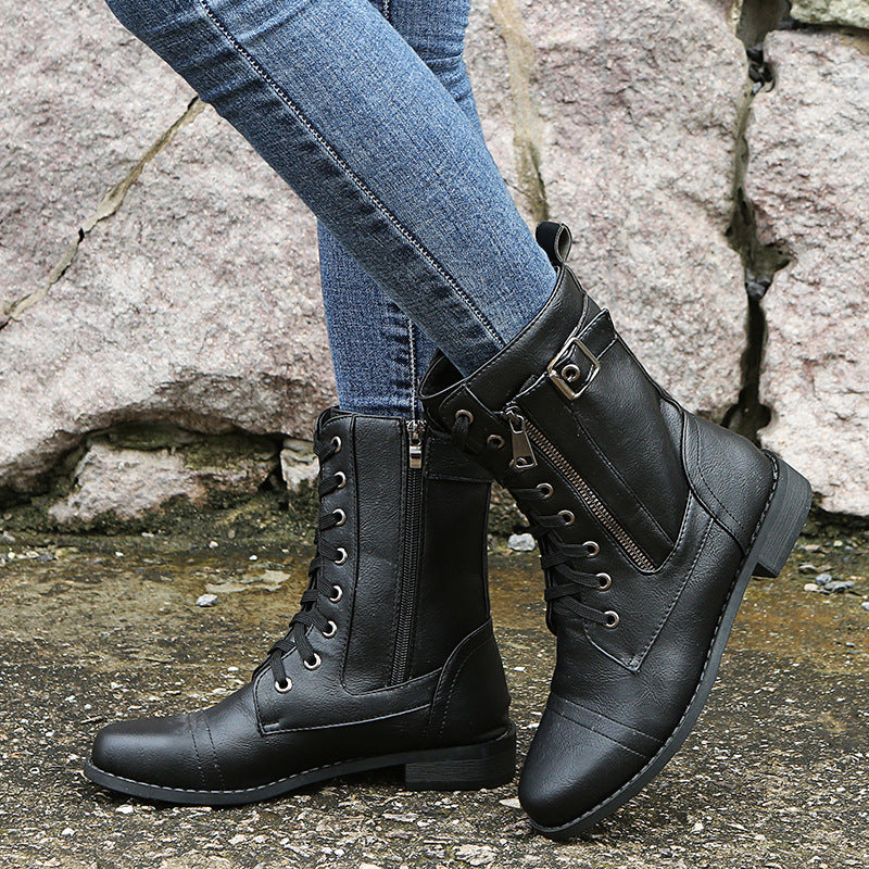 Schwarze Damenstiefel aus Leder mit Schnürung und Reißverschluss, kombiniert mit blauen Jeans. Modische Herbst- und Winterstiefel für Damen.