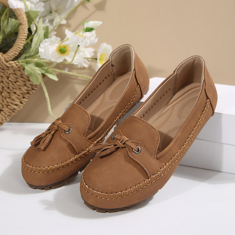 Braune Damen-Mokassins mit Quasten, aus Leder, auf weißem Hintergrund. Perfekt für Freizeitmode. Elegante und bequeme Schuhe für den Alltag.