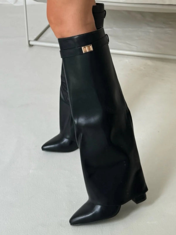 Schwarze, kniehohe Lederstiefel mit spitzer Zehenpartie und goldener Schnalle auf hellem Hintergrund. Modische Damenstiefel, elegantes Design.