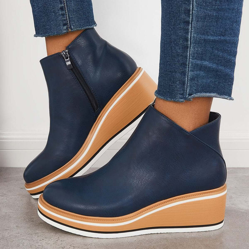 Dunkelblaue Keilabsatz-Stiefeletten mit Reißverschluss, kombiniert mit Jeans. Modische Damen-Schuhe, ideal für Herbst und Winter.