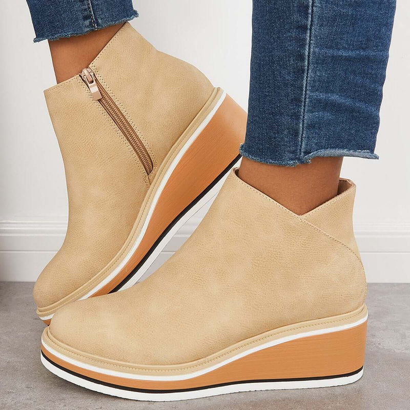 Beige Keilabsatz-Stiefeletten mit Reißverschluss, kombiniert mit blauen Jeans. Modische Damen-Schuhe, ideal für Herbst-Outfits und lässige Looks.