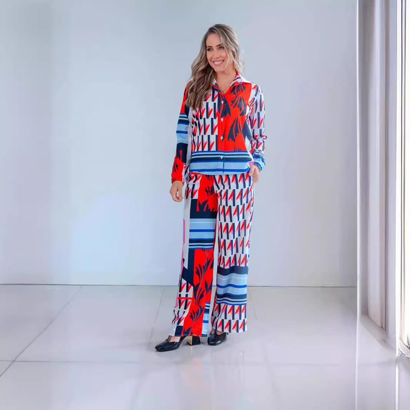 Frau in buntem, geometrisch gemustertem Anzug, lächelt in modernem, minimalistischem Raum. Modetrend, Damenbekleidung, stilvolles Outfit.