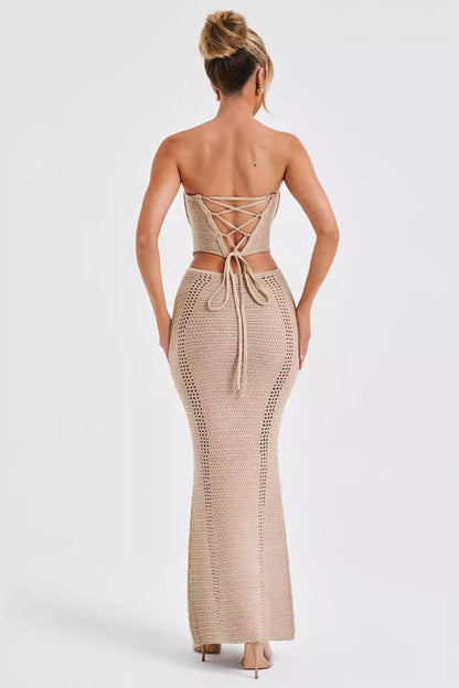 Frau in beige, rückenfreiem, gehäkeltem Maxikleid mit Schnürung, elegantes Abendoutfit, modisches Design, Sommermode, stilvolle Damenbekleidung.