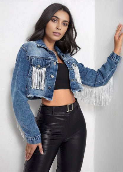Frau in modischer Jeansjacke mit Fransen, schwarzem Top und Lederhose. Trendige Damenmode, lässiger Look, Streetstyle, Denim, Fransenjacke.