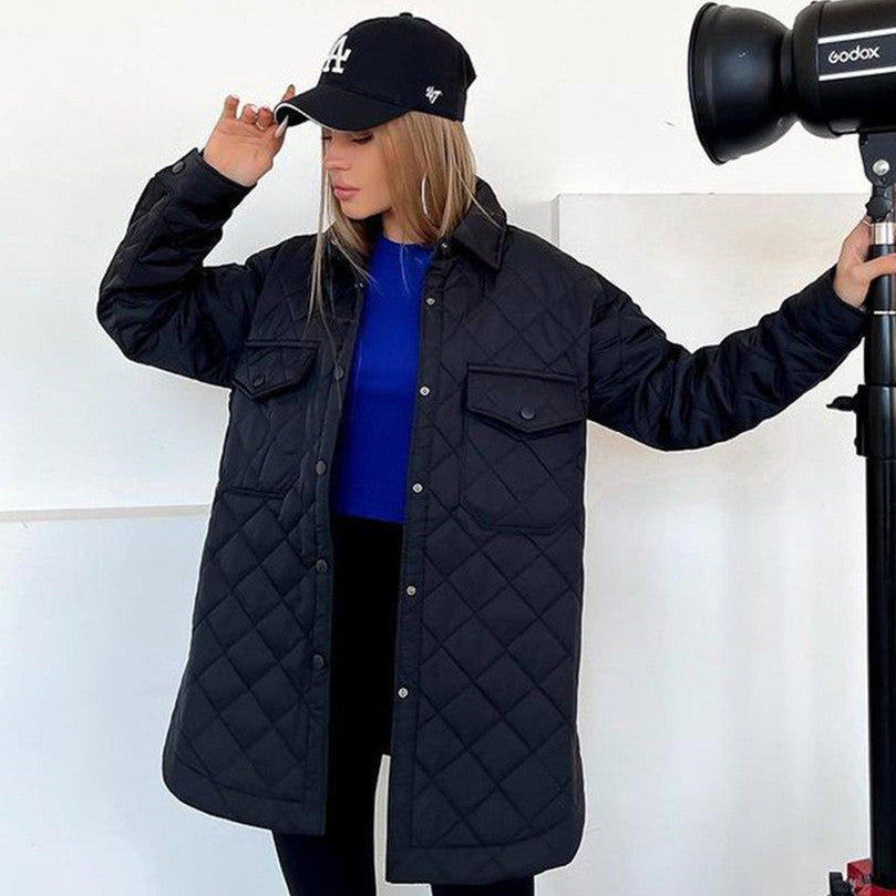 Frau in gesteppter schwarzer Jacke und Baseballkappe posiert neben Fotolicht. Modetrend, Herbstmode, Damenbekleidung, Outdoor-Jacke.