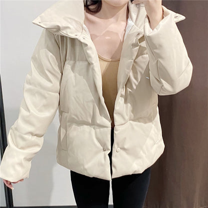 Frau in beiger Daunenjacke, modisch, warm, Winterkleidung, Indoor-Aufnahme, stilvoll, bequeme Passform, Trendmode, Damenbekleidung.