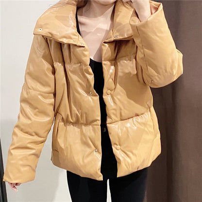 Frau trägt beige, glänzende Daunenjacke, modisch, warm, Winterkleidung, Damenmode, stilvoll, Outdoor, Herbst, Winterjacke, trendig.