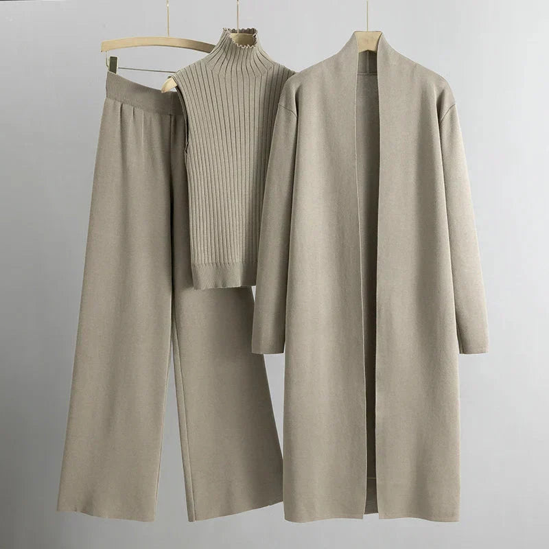 Beiges Damen-Outfit-Set mit langem Mantel, ärmellosem Rollkragenpullover und weiter Hose. Elegante, minimalistische Mode für Herbst und Winter.