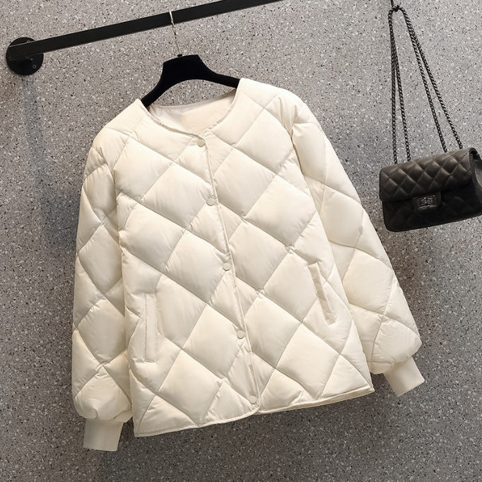 Weiße gesteppte Damenjacke auf Bügel, minimalistisch, mit Taschen, vor grauem Hintergrund. Modische Winterbekleidung, warm und stilvoll.