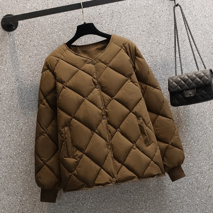 Braune Steppjacke auf Bügel vor grauer Wand, modisch und warm, ideal für Herbst und Winter. Neben der Jacke hängt eine schwarze Umhängetasche.