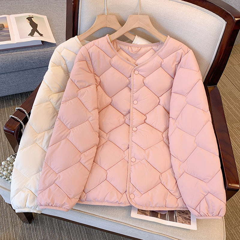 Zwei gesteppte Damenjacken in Rosa und Beige auf einem Sessel, modisch und warm, ideal für Herbst und Winter. Hochwertige Daunenjacken.