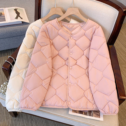 Zwei gesteppte Damenjacken in Rosa und Beige auf einem Sessel, modisch und warm, ideal für Herbst und Winter. Hochwertige Daunenjacken.