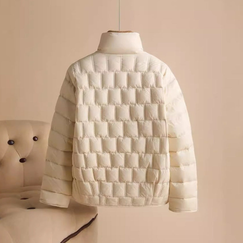 Weiße Daunenjacke auf beigem Hintergrund, modisch und warm, ideal für Winterkleidung. Hochwertige Steppjacke, stilvoll und bequem.