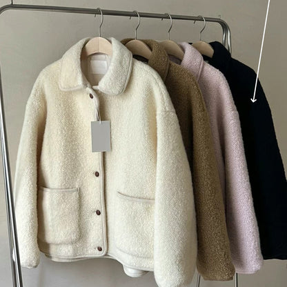 Vier flauschige Jacken auf Kleiderstange, Farben: Weiß, Beige, Rosa, Schwarz. Modetrend Herbst/Winter, warme Damenjacken, stilvoll und gemütlich.