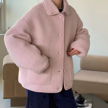 Person in rosa Teddyjacke in modernem Wohnzimmer. Kuschelige, modische Winterjacke, ideal für kalte Tage. Trendige Damenbekleidung.