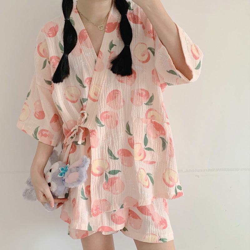 Frau in rosa Kimono mit Pfirsichmuster, hält eine Plüschhandtasche. Sommermode, lässiger Stil, asiatische Kleidung, trendiges Design.