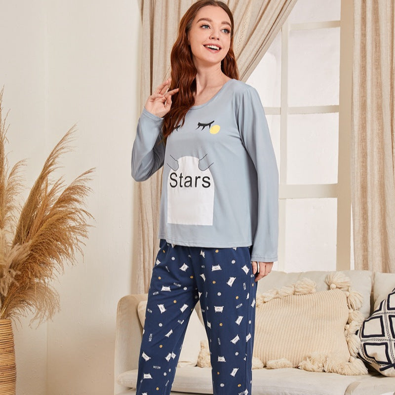 Frau in gemütlichem Pyjama mit Sternenmuster, lächelt im Wohnzimmer. Bequeme Nachtwäsche, modische Schlafanzüge, entspannte Atmosphäre.