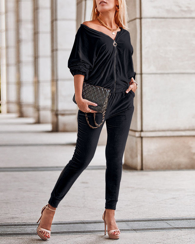 Frau in eleganter schwarzer Freizeitkleidung, hält eine gesteppte Handtasche, trägt hohe Absätze. Stilvolle Mode, urbaner Chic, modernes Outfit.