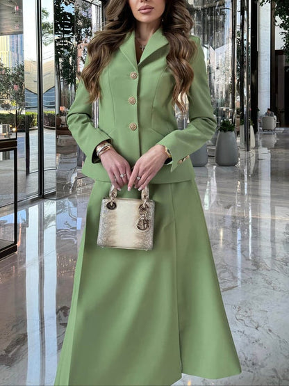 Frau in eleganter, grüner Anzugjacke und Rock, hält eine goldene Designer-Handtasche. Luxuriöse Hotellobby im Hintergrund. Fashion, Stil, Mode.