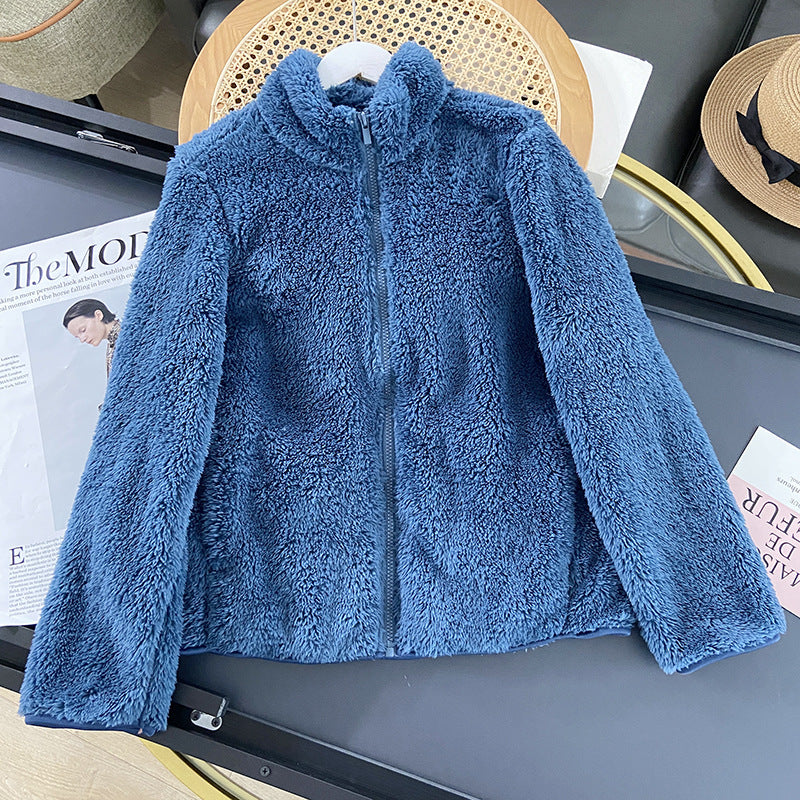Blaue Fleecejacke mit Reißverschluss auf Tisch, modisch und warm, ideal für Herbst und Winter. Perfekt für Outdoor-Aktivitäten und Freizeitkleidung.