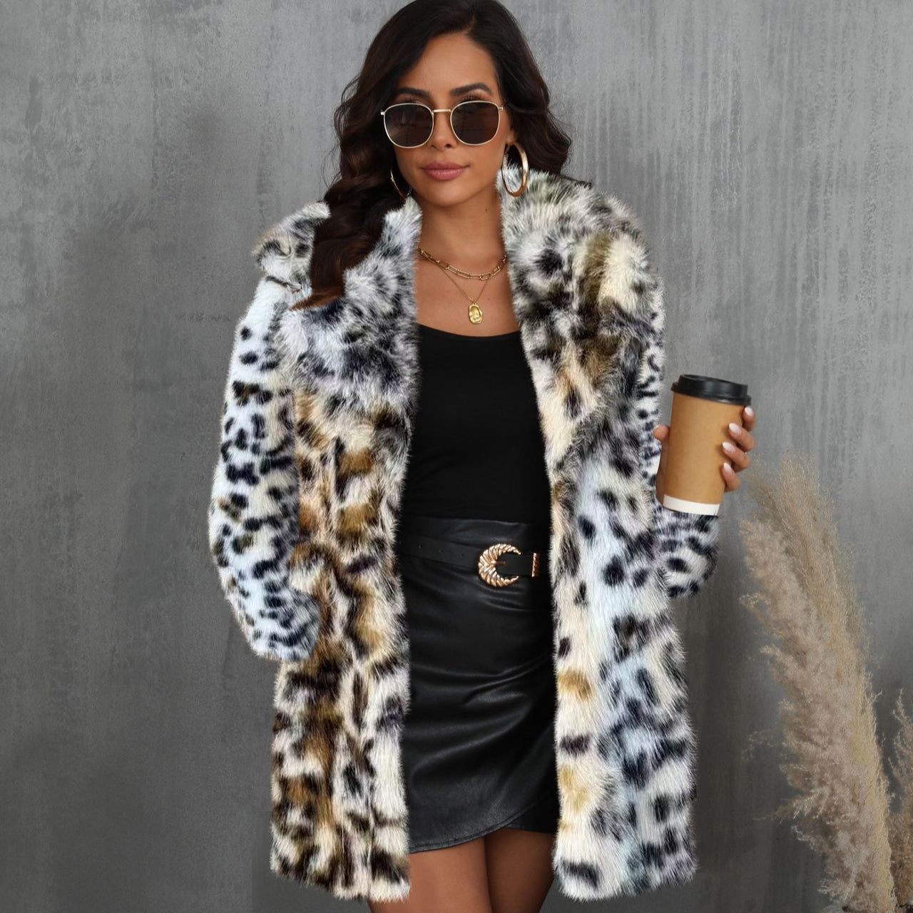 Frau in stilvollem Leopardenmuster-Mantel, schwarzem Kleid, Sonnenbrille und Kaffeebecher. Elegante Mode, Herbst-Outfit, trendige Accessoires.