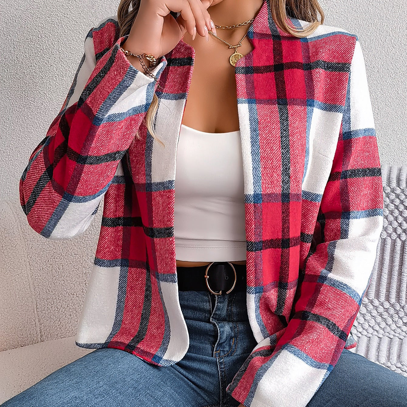 Frau trägt rot-karierten Blazer, weißes Top und Jeans. Modetrend, stilvolle Damenbekleidung, lässiger Look, Herbstmode 2023.