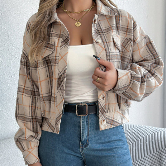 Frau trägt karierte Jacke, weißes Top und Jeans. Modetrend Herbst 2023, lässiger Look, Damenmode, stilvolle Freizeitkleidung.