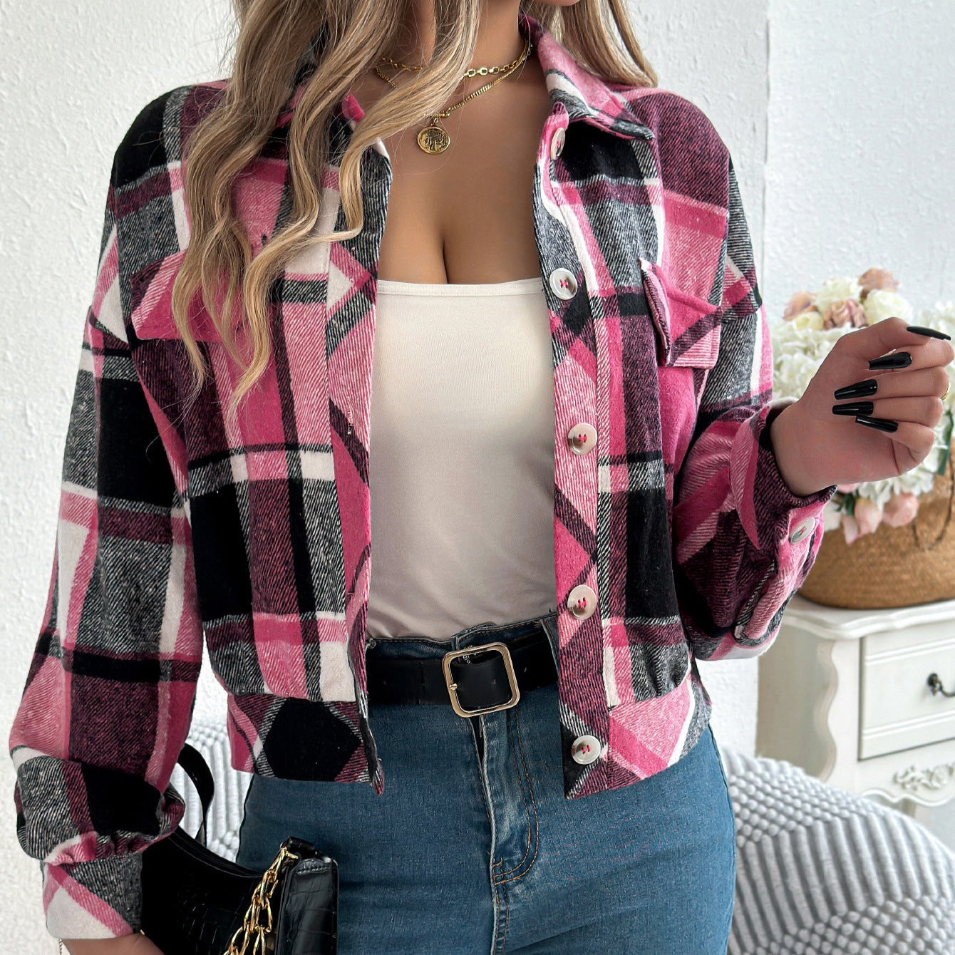 Frau trägt karierte rosa Jacke, weißes Top und Jeans. Modetrend, Herbstmode, lässiger Stil. Perfekt für stilvolle Freizeitoutfits.