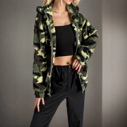 Frau in Camouflage-Jacke und schwarzem Top, modisch gekleidet, lässiger Stil, urbaner Look, trendige Damenmode, Herbst-Outfit.