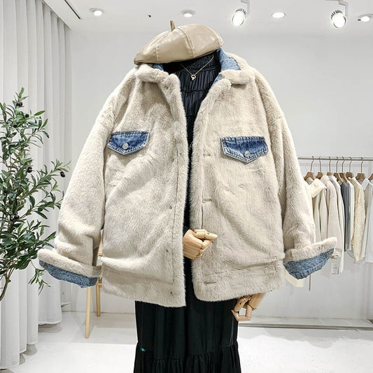 Beige Kunstpelzjacke mit blauen Jeansakzenten, ausgestellt in einem modernen Bekleidungsgeschäft. Trendige Wintermode, stilvoll und warm.