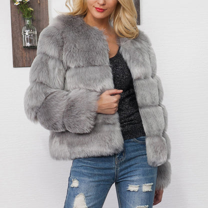Blonde Frau in grauer Kunstpelzjacke, schwarze Glitzerbluse und zerrissenen Jeans vor weißer Wand. Modetrend, Wintermode, stilvolle Damenbekleidung.