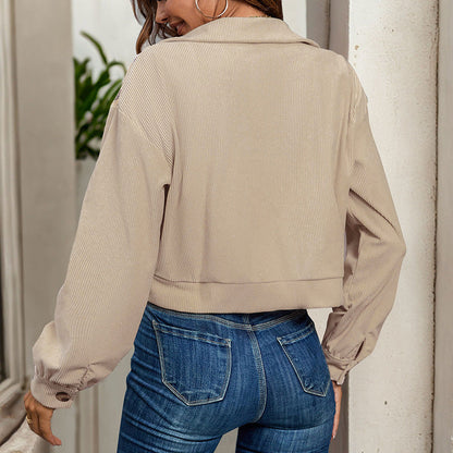 Frau in beiger Jacke und blauer Jeans von hinten, lässiger Stil, moderne Damenmode, urbaner Look, Herbstkleidung, Outdoor-Aufnahme.