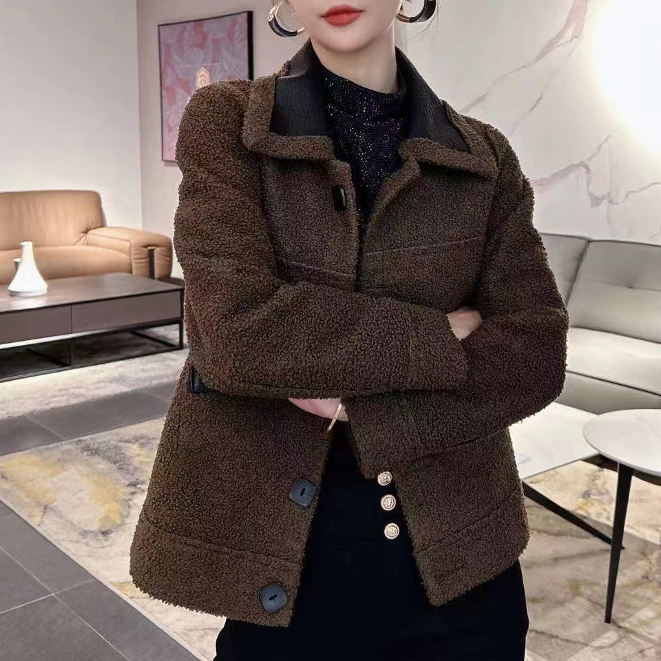 Frau in brauner Teddyjacke, schwarzem Oberteil und schwarzer Hose in modernem Wohnzimmer. Modetrend, Herbstmode, Damenbekleidung.