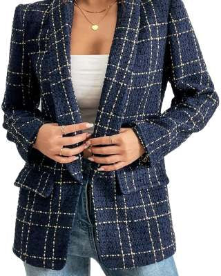 Frau trägt karierten Blazer in Dunkelblau mit weißen Streifen, kombiniert mit weißem Top und blauer Jeans. Modetrend, eleganter Damenblazer.