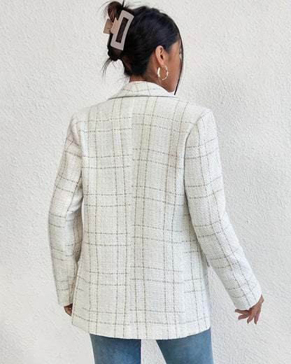 Frau mit weißem kariertem Blazer, Haarclip und goldenen Ohrringen, Rückansicht. Modetrend, eleganter Look, Damenmode, stilvoller Blazer.