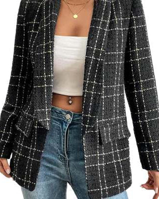 Frau in kariertem Blazer, weißem Top und blauer Jeans. Modetrend, eleganter Blazer-Look, stilvolle Damenbekleidung, Freizeitoutfit.