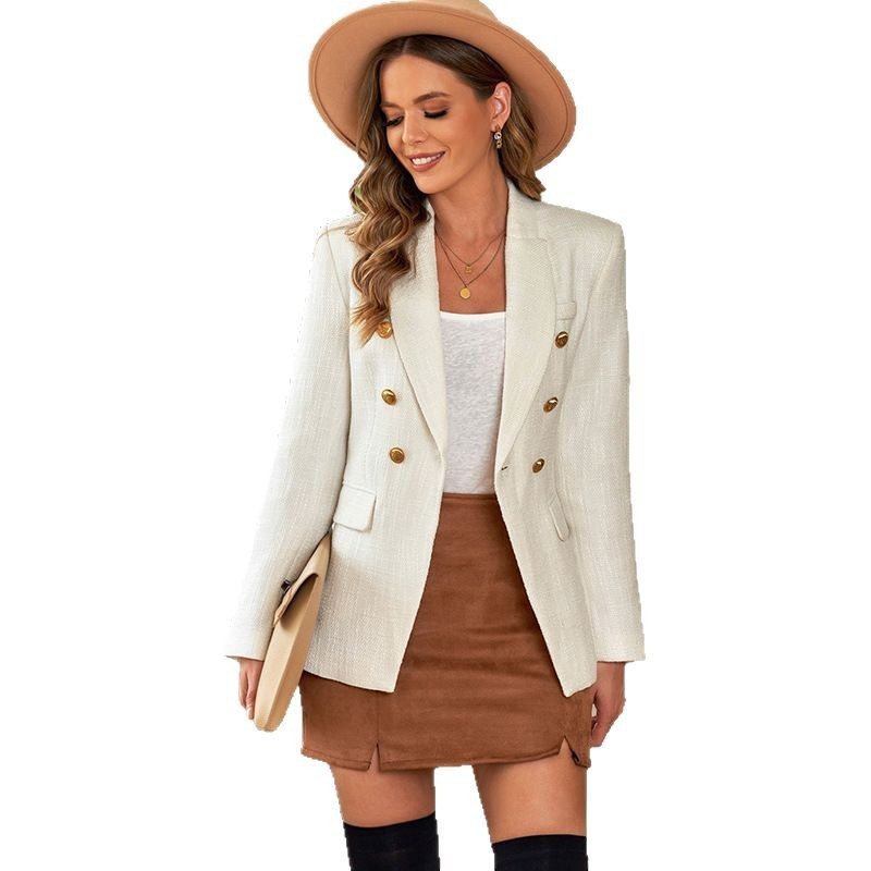 Frau in weißem Blazer, braunem Rock und Hut, lächelnd. Modetrend Herbst, elegante Damenmode, stilvoller Look, Streetstyle Outfit.