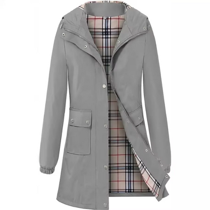 Grauer Damenmantel mit Kapuze, kariertem Innenfutter und Taschen. Stilvoller Regenmantel, ideal für Herbstmode und Outdoor-Aktivitäten.