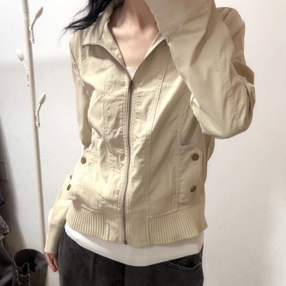 Beige Damenjacke mit Reißverschluss, langen Ärmeln und Taschen, getragen von einer Person. Modische Oberbekleidung, ideal für Herbst und Frühling.
