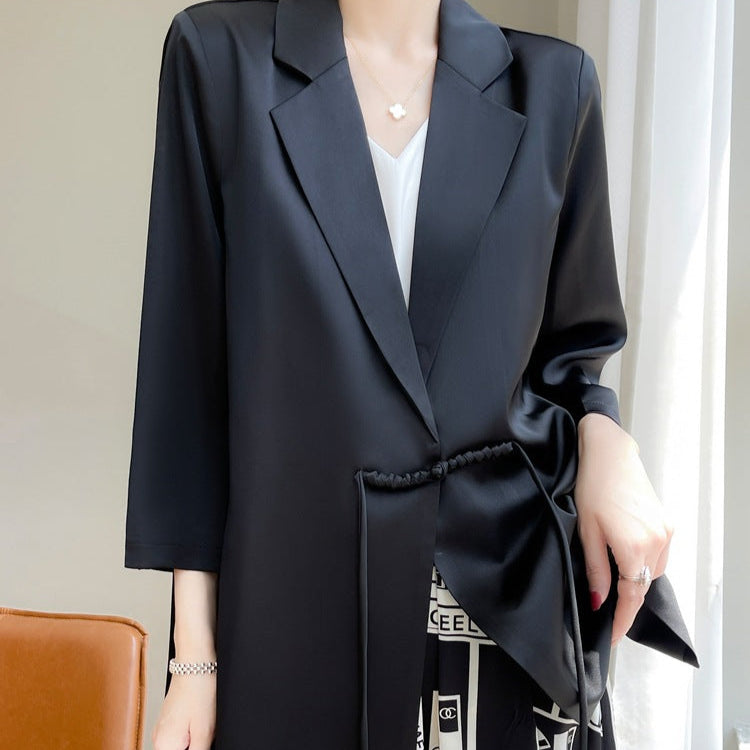 Eleganter schwarzer Blazer für Damen, lässig offen getragen, mit weißem Top und gemustertem Rock. Perfekt für Business- und Freizeitoutfits.