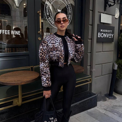 Frau in Leopardenjacke und Sonnenbrille vor einem Café in der Stadt. Mode, Streetstyle, urbane Kleidung, trendige Outfits, stilvolle Frau.