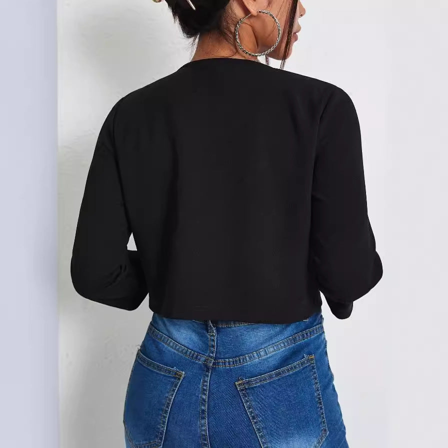 Frau in schwarzem Langarmshirt und blauer Jeans, Rückansicht. Modetrend, lässiger Stil, Damenbekleidung, Herbstmode.